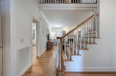 Staircase featuring wood finished floors, crown mo