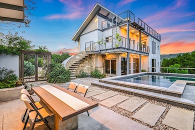 Back of property featuring a balcony, stairway, a