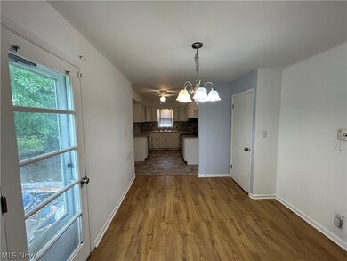 Unfurnished dining area with an inviting chandelier, sink, and light wood-type flooring
