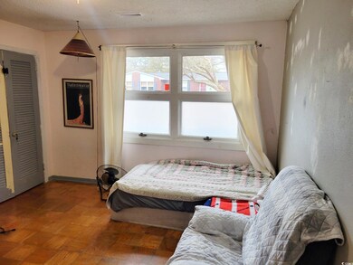 Bedroom with parquet floors and a textured ceiling