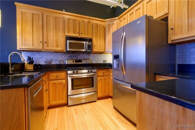 Kitchen with dark stone countertops, tasteful back