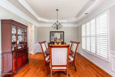 Dining room features tray ceilings, wainscot paneling, beautiful crown molding and plantation shutters 
