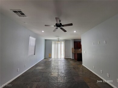 Empty room featuring stone tile floors, ceiling fa
