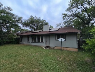 Back of property featuring solar panels, a lawn, 