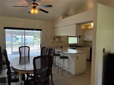 Tiled dining space featuring lofted ceiling and a 