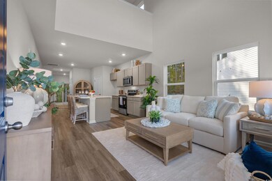 Living area featuring dark wood-style flooring, a high ceiling, and recessed lighting