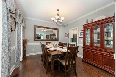 Dining area with a chandelier, dark wood finished floors, and ornamental molding