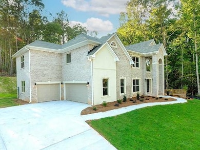 View of front facade with a front yard, driveway, a garage, and stucco siding
