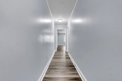 Hallway featuring wood finished floors, baseboards
