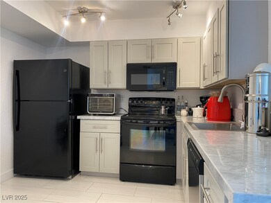 Kitchen with black appliances, track lighting, and