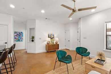 Living area featuring baseboards, concrete floori