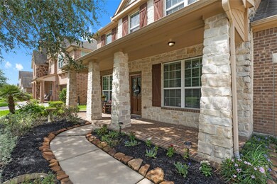 Craftsman-inspired stone columns frame the expansive, covered front porch.