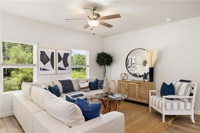 Living area with light wood-type flooring, a ceiling fan, and baseboards