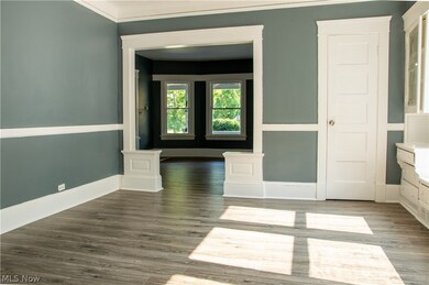Unfurnished room with dark hardwood / wood-style floors and crown molding