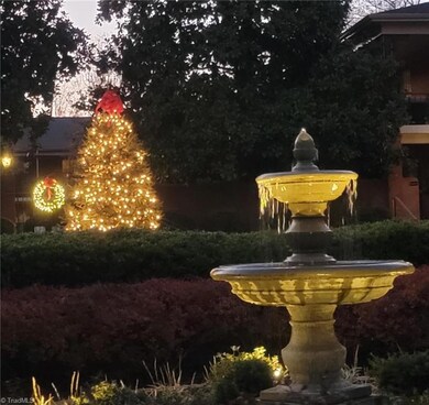 Scenic courtyard through the breezeway with lighted fountain & evergreen tree lit at night for your  Holiday enjoyment.
