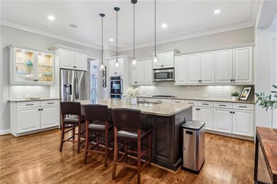 Kitchen with appliances with stainless steel finishes, tasteful backsplash, light wood-style flooring, white cabinetry, and recessed lighting