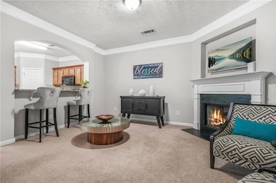 Living area with carpet flooring, arched walkways,