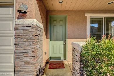 Entrance to property with a garage, stone siding,