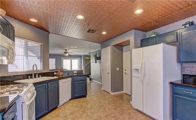 Kitchen with visible vents, dark countertops, whit