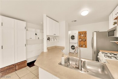 Kitchen featuring stacked washer and dryer, stainl