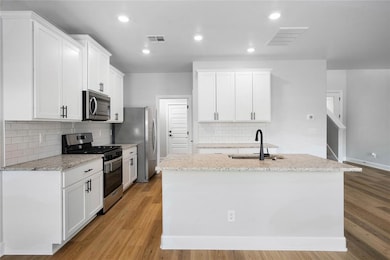Spacious island with undermount sink and matte black faucet—great for entertaining.