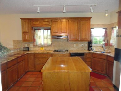 Island in spacious kitchen with terrazo tile