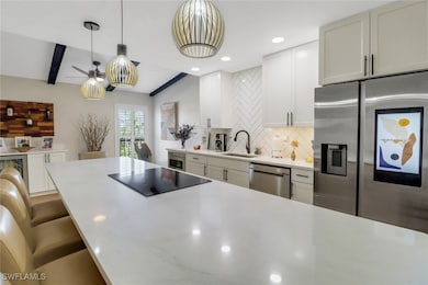 Kitchen featuring sink, white cabinetry, backsplas