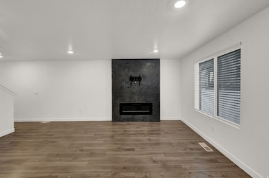 Unfurnished living room with a high end fireplace, recessed lighting, and wood finished floors