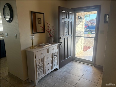 Entryway featuring a textured wall and light tile patterned floors