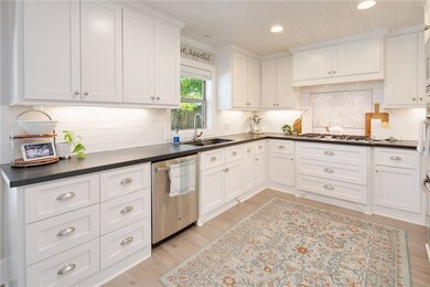 Kitchen featuring white cabinets, dark countertops