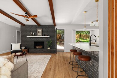 Living room featuring beamed ceiling, light wood 