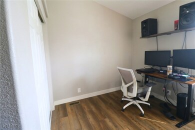 Office with dark wood-type flooring and baseboards