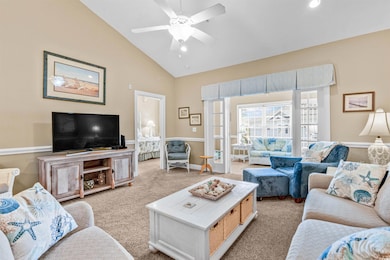 Carpeted living room with ceiling fan, high vaulted ceiling, and recessed lighting