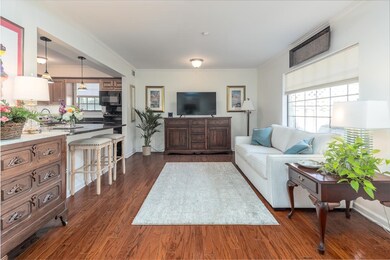 Living room with ornamental molding, dark hardwood
