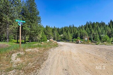 View of road featuring a wooded view and a gate