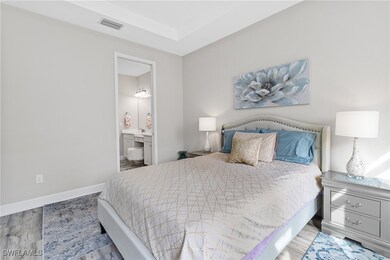 Bedroom featuring ensuite bathroom, light wood-sty