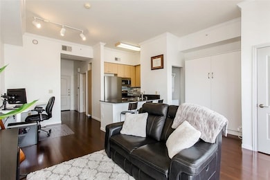 Living area featuring ornamental molding, a desk, dark wood finished floors, and track lighting