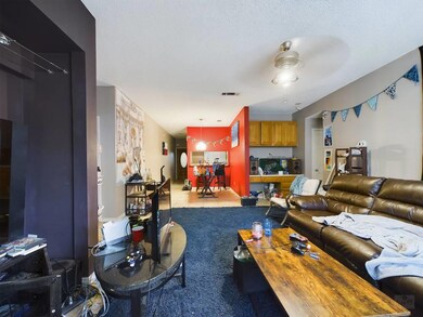 Carpeted living area with visible vents and a cei