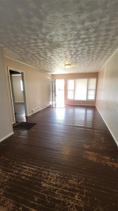 Unfurnished living room featuring dark wood-style floors and wood walls