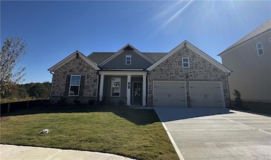 Craftsman house featuring stone siding, a front lawn, driveway, a porch, and board and batten siding