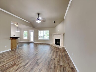 Unfurnished living room featuring a premium fireplace, lofted ceiling, wood finished floors, a ceiling fan, and a chandelier