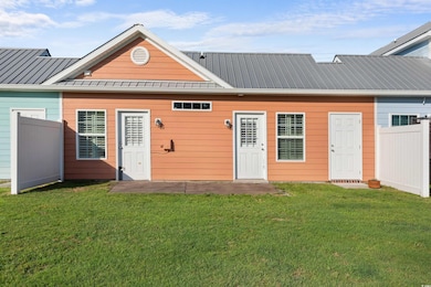Back of property with metal roof and a standing seam roof