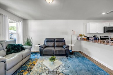 Living area with baseboards, wood finished floors,