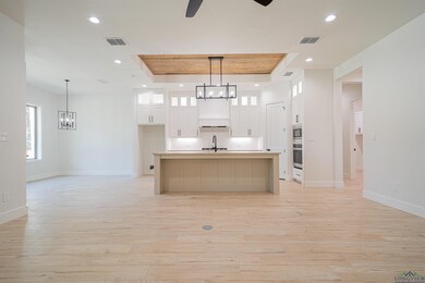 Kitchen featuring white cabinetry, light hardwood 