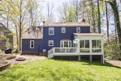 Rear view of property with a chimney, a lawn, an o