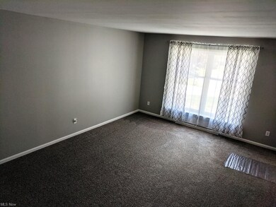 The living room has 2 large windows and new carpet