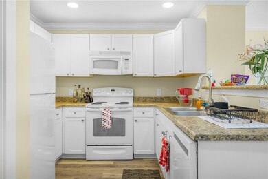 Kitchen with white appliances, light wood-type flo
