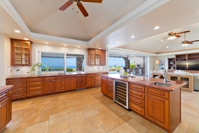 Chef’s kitchen with open layout and a pass-through window to the covered lanai.