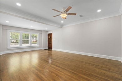 Unfurnished room featuring ornamental molding, ceiling fan, baseboards, dark wood-type flooring, and recessed lighting
