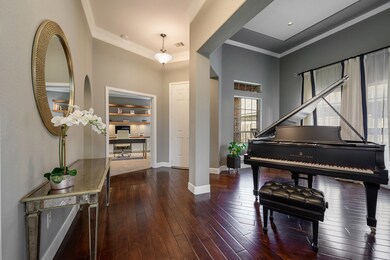 Entry features stunning wood flooring and crown molding.